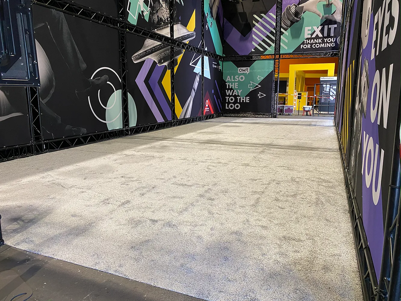 Hochfloriger Messeteppich im Lounge-Bereich der OMR Hamburg – moderne Messeausstattung mit farbigen Grafikwänden.