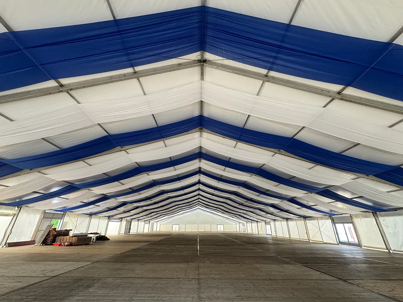 Zelthimmel in Weiß und Blau im Festzelt mit Holzfußboden – klassische Oktoberfest-Dekoration mit Stoffbahnen.