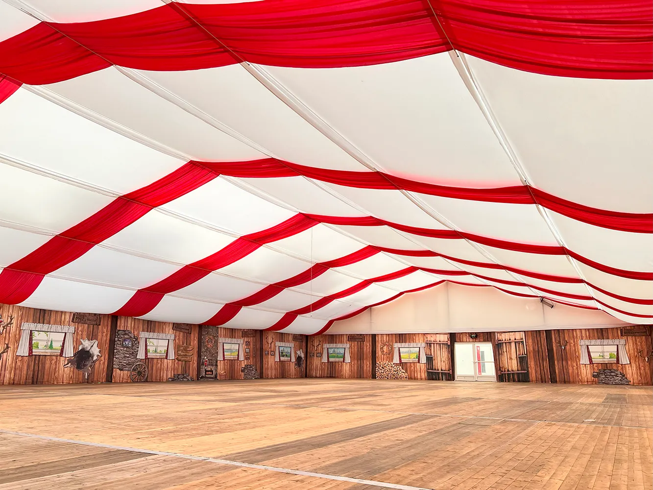 Zelthimmel in Weiß und Rot im Festzelt mit Holzoptik-Seitenwänden – festliche Dekoration für Events und Oktoberfeste.
