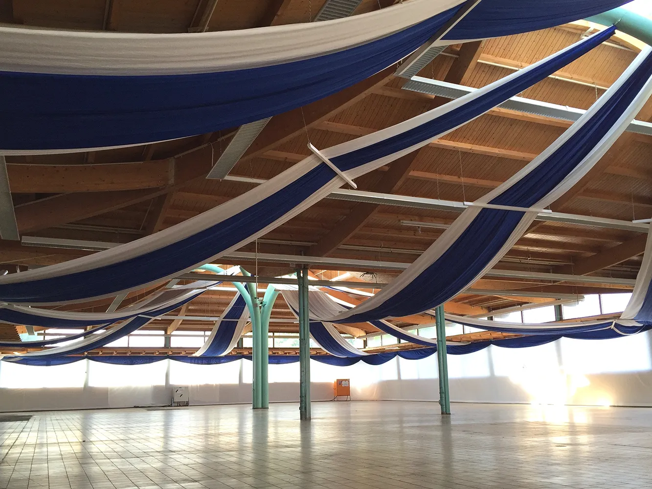 Blau-weiße Stoffbahnen von Skydeko als Hallendekoration für große Events und Festhallen.