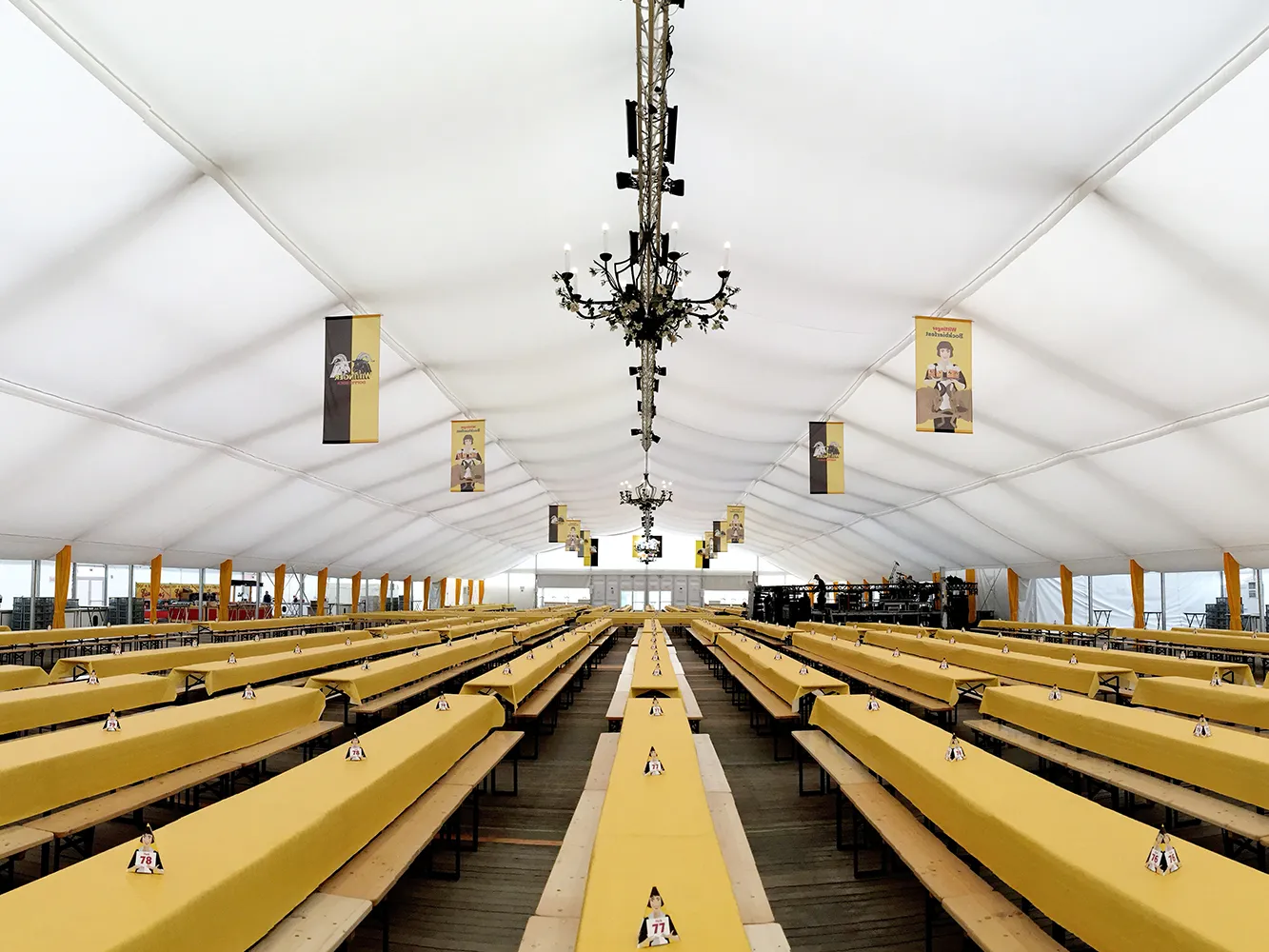 Festzelt mit weißem Zelthimmel, gelber Tischdekoration und Kronleuchtern – Eventausstattung für Großveranstaltungen von Skydeko.